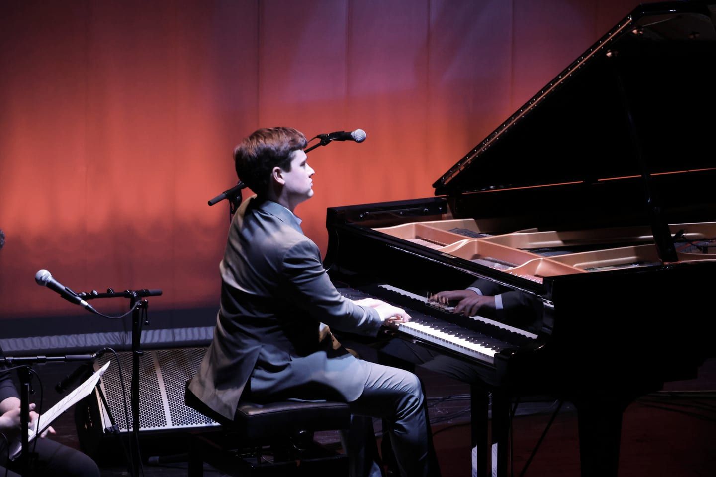 Javier Cecilia al piano durante Aires de Pasión, sobre un fondo cálido de escenario